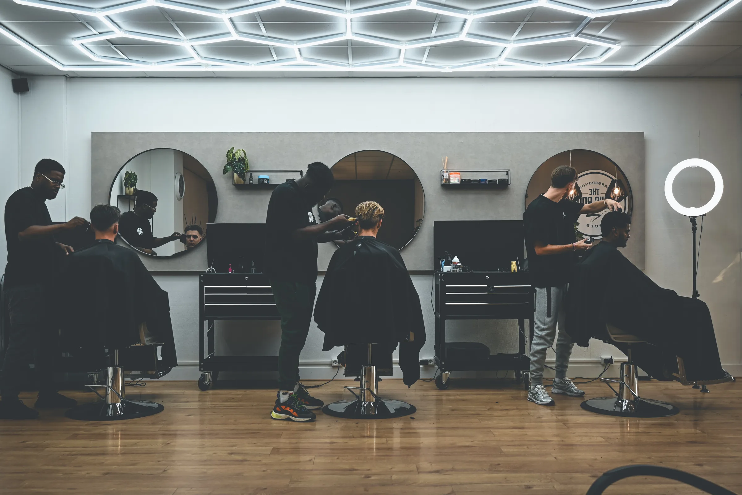 Barbers aan het werk in The Men's Room barbershop